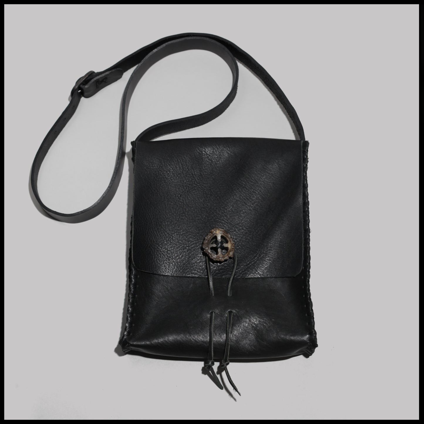 Black hand-stitched leather shoulder bag w/ hand-carved Deer antler Sun Wheel closure