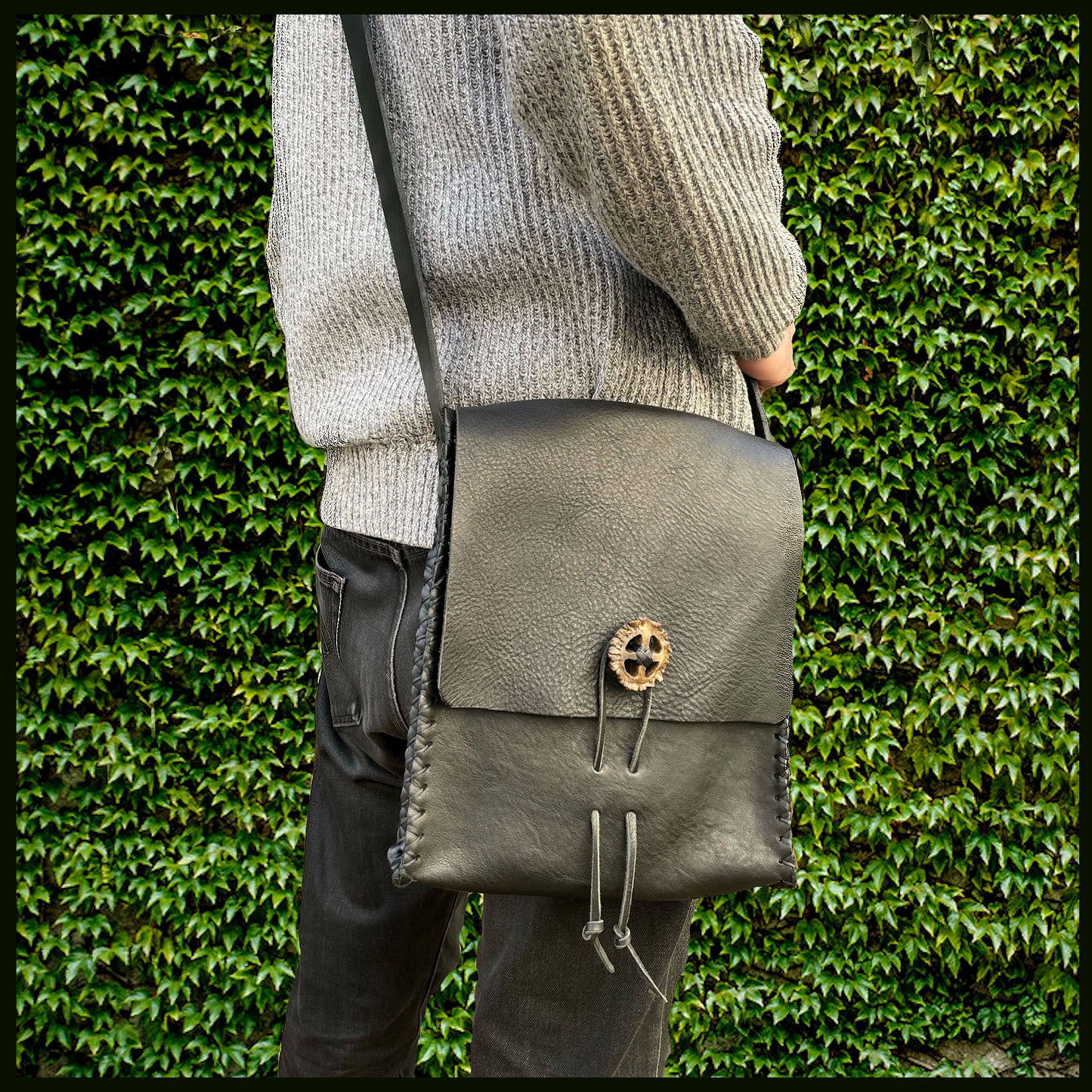 Black hand-stitched leather shoulder bag w/ hand-carved Deer antler Sun Wheel closure