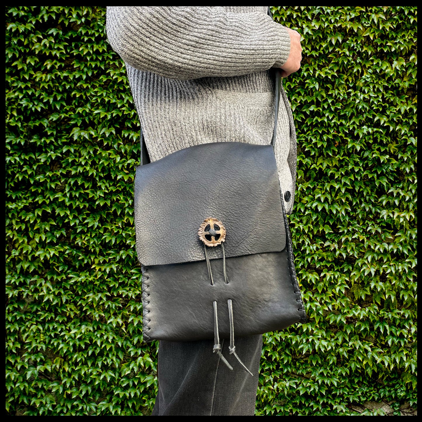 Black hand-stitched leather shoulder bag w/ hand-carved Deer antler Sun Wheel closure